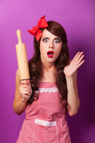Beautiful brunette housewife with rolling pin on violet backgrou - Photo, Image