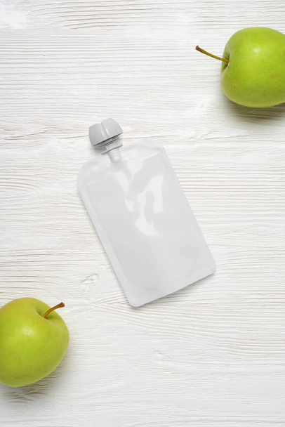 Bílý plastový sáček na dětskou výživu, ovocný pyré na dřevěném stole. Šablona pro návrh. 3D vykreslování ilustrace. - Fotografie, Obrázek