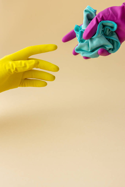 Hand in Hand mehrfarbige Gummihandschuhe mit einem Mikrofasertuch zum Waschen, Reinigungskonzept - Foto, Bild