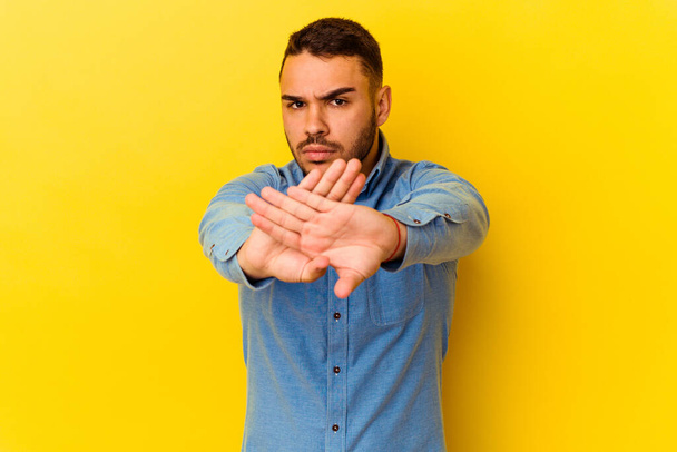 Young caucasian man isolated on yellow background doing a denial gesture - Photo, Image
