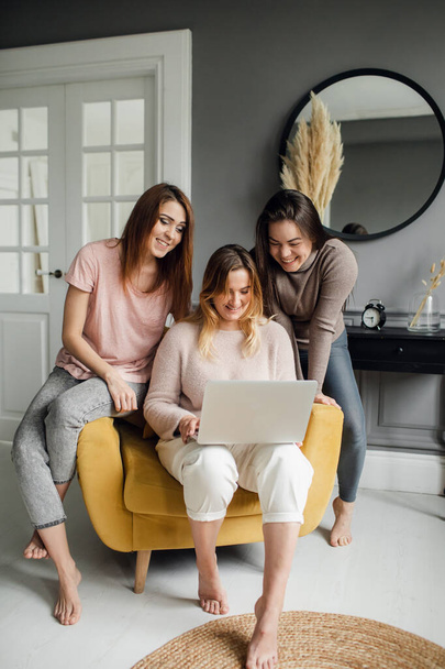 girlfriends students do tasks together on a laptop at home - Φωτογραφία, εικόνα