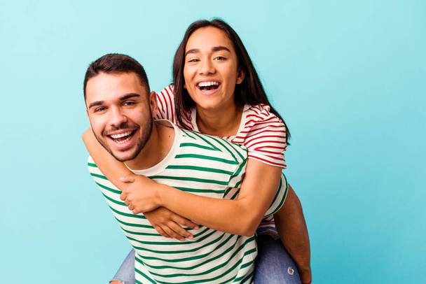 Young mixed race couple isolated on blue background - Photo, Image