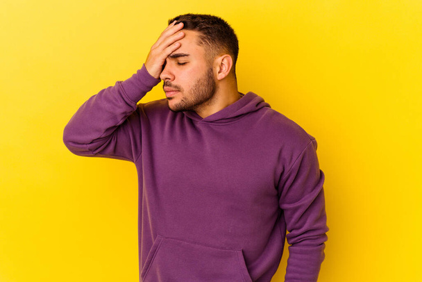 Young caucasian man isolated on yellow background having a head ache, touching front of the face. - Foto, immagini