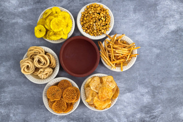Selective focused Traditional Indian Diwali salty snacks and foods items and empty lamp on an isolated background. Tamilnadu snacks for the Diwali festival. - Photo, Image
