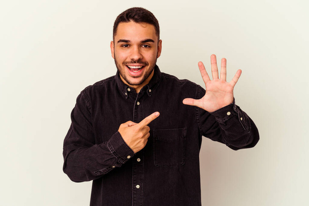 Young caucasian man isolated on white background smiling cheerful showing number five with fingers. - Photo, Image