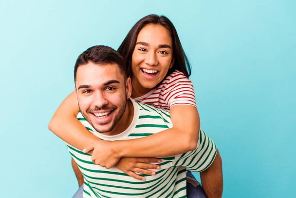 Young mixed race couple isolated on blue background - Photo, Image