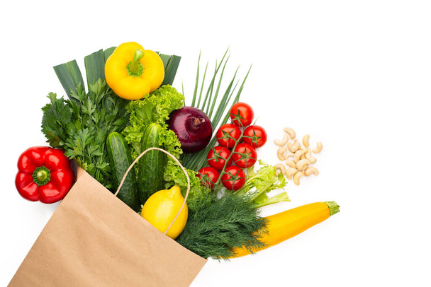 白い背景に隔離された紙袋に野菜やハーブのセット。コンセプト:スーパーマーケットや市場での買い物と健康的なベジタリアンフード. - 写真・画像