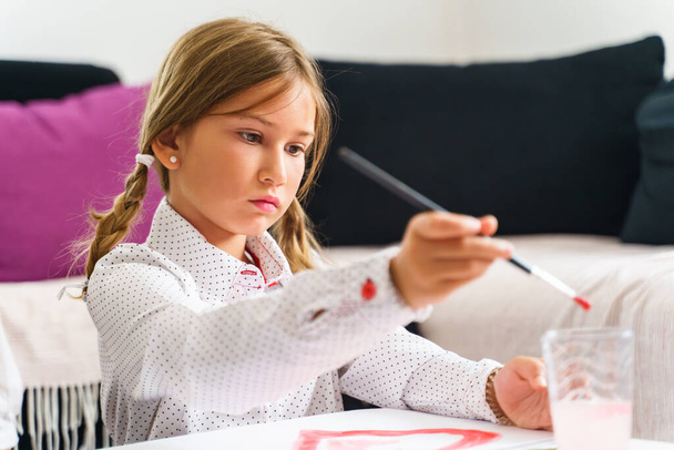 Evdeki küçük beyaz kız resmine yakından bakın - küçük çocuk resim dersini bitirmek için boya fırçası kullanıyor - okul yaratıcılığı çocukluğuna ve büyüyen konsepte geri dönüyor - Fotoğraf, Görsel