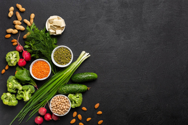 菜食主義者のためのタンパク質:豆腐,野菜,ナッツ,種子と黒の背景にマメ科植物トップビュー.コンセプト:健康的なきれいな食品。スペースのコピー. - 写真・画像