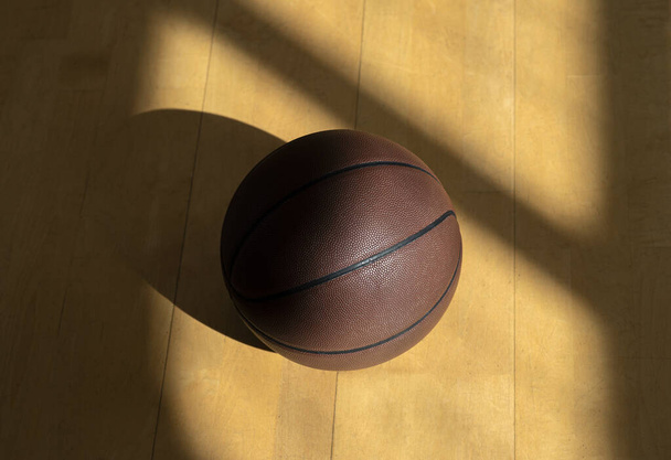 Cancha de baloncesto piso de madera con bola de cuero marrón profesional y sombras. Cartel deportivo horizontal, tarjetas de felicitación, encabezados, sitio web - Foto, Imagen