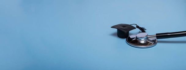 Stethoscope and graduate hat, on a blue background, top view, medical background graduate achievement, background, banner - Photo, Image