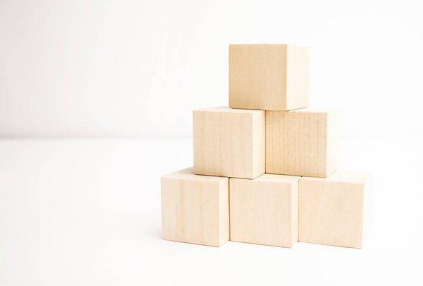 Wooden blocks stacking as a pyramid staircase on white background. - Foto, imagen