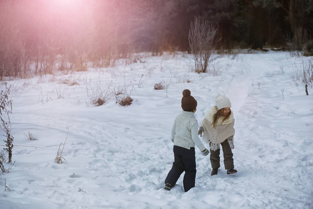 Щаслива сім'я грає і сміється взимку на свіжому повітрі в снігу. Міський парк зимовий день
 - Фото, зображення