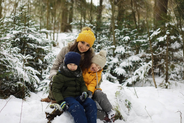 Gelukkig familie spelen en lachen in de winter buiten in de sneeuw. Stadspark winterdag. - Foto, afbeelding