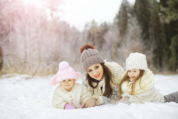 Onnellinen perhe leikkii ja nauraa talvella ulkona lumessa. Kaupungin puisto talvipäivä - Valokuva, kuva