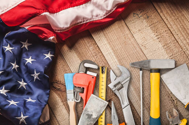 Happy Labor day concept. American flag with different construction tools on dark stone background, with copy space for text. - Foto, immagini
