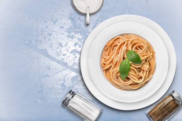 Spaghetti with meat in tomato sauce in a bowl on a desk - Foto, afbeelding