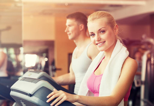 Attractive couple doing training program in the fitness center or gym, - Фото, изображение