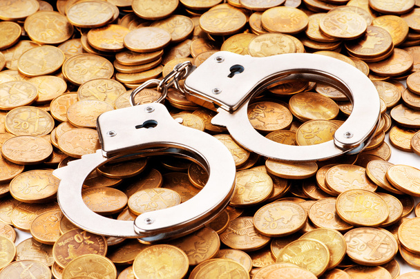 Hand cuffs and coins as security concept - Photo, Image