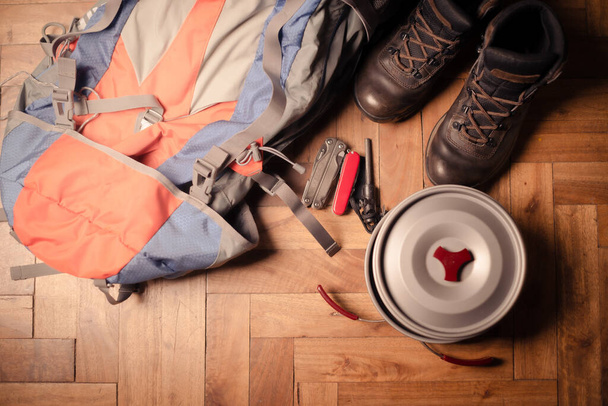 A top view of a backpack, footwear, and hiking equipment on the floor - Photo, Image