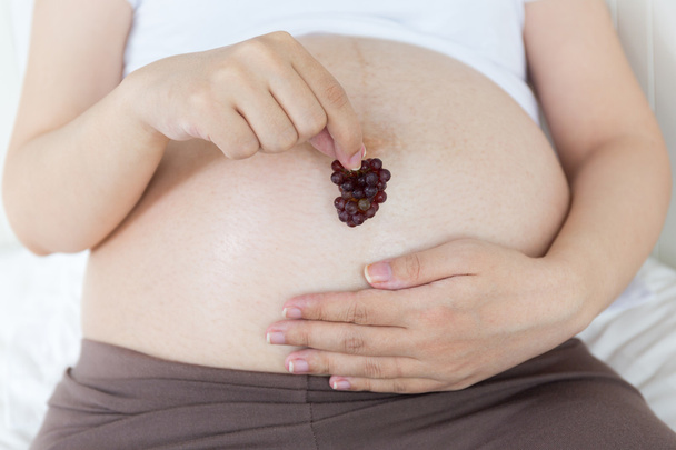 Pregnant belly with cherry - Photo, Image