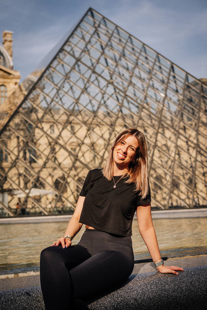 Turista in posa davanti al Museo del Louvre a Parigi, Francia - Foto, immagini