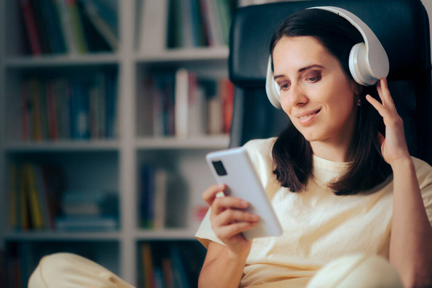 Mulher feliz segurando Smartphone ouvindo música em casa - Foto, Imagem