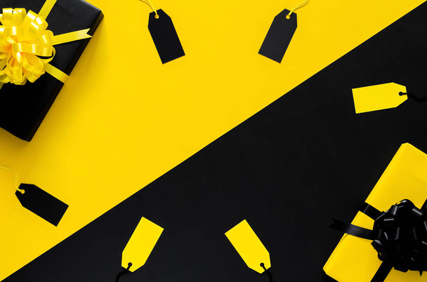 Boîtes cadeaux jaunes et noires avec ruban et étiquettes de prix vierges sur fond noir et jaune. Concept Black Friday et Boxing Day. - Photo, image