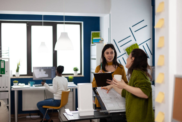 İş kadınlarından oluşan bir ekip yaratıcı stüdyo ofisinde duruyor. - Fotoğraf, Görsel