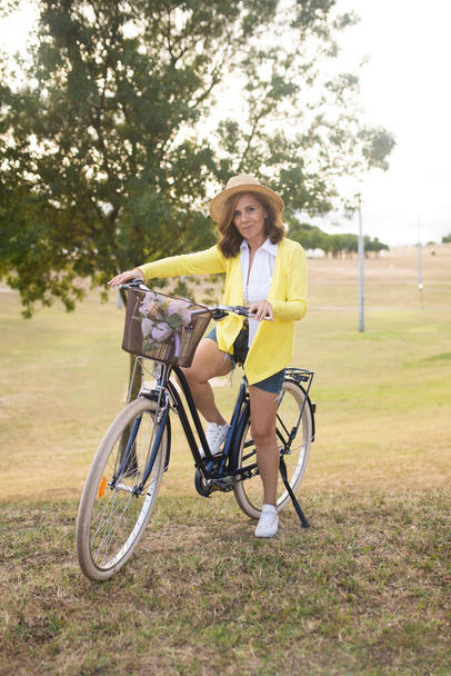 Retrato de atractiva mujer madura en bicicleta - Foto, imagen