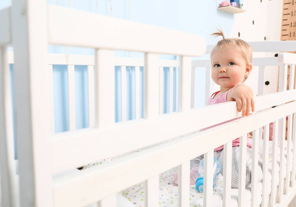 Cute baby girl in cot at home - Valokuva, kuva