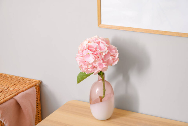 Jarrón con flores de hortensias en la mesa cerca de la pared de color - Foto, Imagen