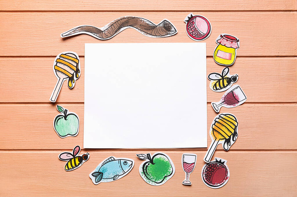Paper symbols of Rosh hashanah (Jewish New Year) and empty card on color wooden background - Photo, Image