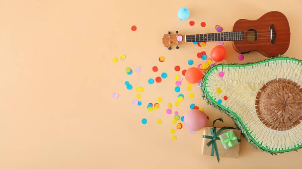 Composición con piñata mexicana, globos, regalos y guitarra sobre fondo de color - Foto, Imagen