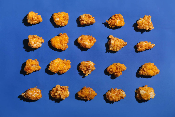 Pollo de palomitas fritas sobre fondo azul - Foto, imagen