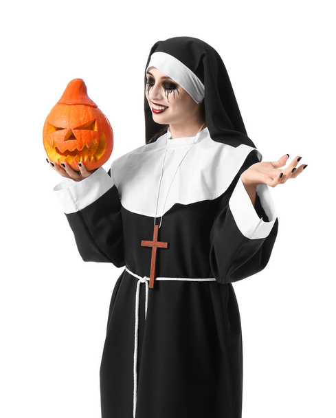 Femme habillée pour Halloween comme nonne avec citrouille sur fond blanc - Photo, image