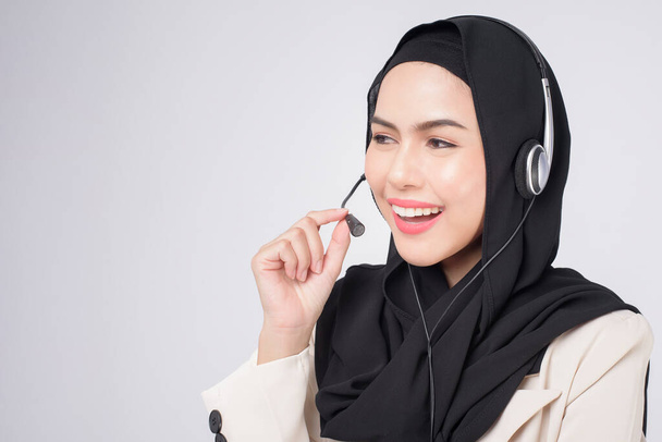 Customer service operator muslim woman in suit wearing headset over white background studio	 - Photo, Image