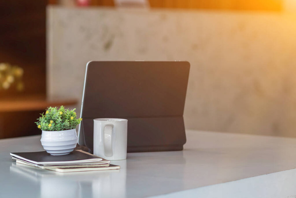 wazig foto, laptop en document geplaatst op het bureau venster om energie te besparen als het gebruik maakt van natuurlijk licht om te helpen werken tijdens de dag en maken zakenmensen blij om te werken en te praten business. - Foto, afbeelding