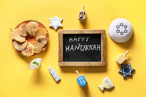 Tableau avec texte HAPPY HANUKKAH et différents symboles sur fond de couleur - Photo, image