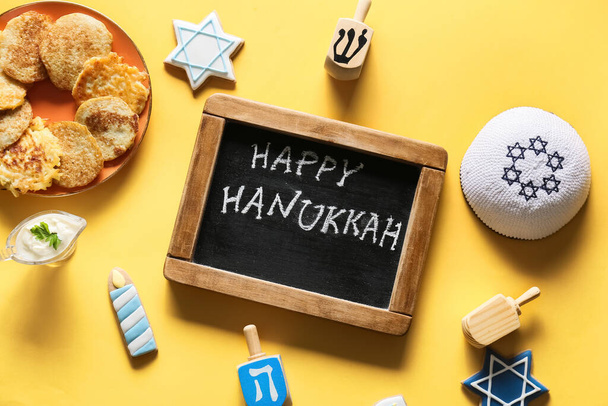 Chalkboard with text HAPPY HANUKKAH and different symbols on color background - Foto, afbeelding