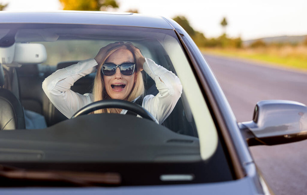 Shocked woman screaming in car - Foto, imagen