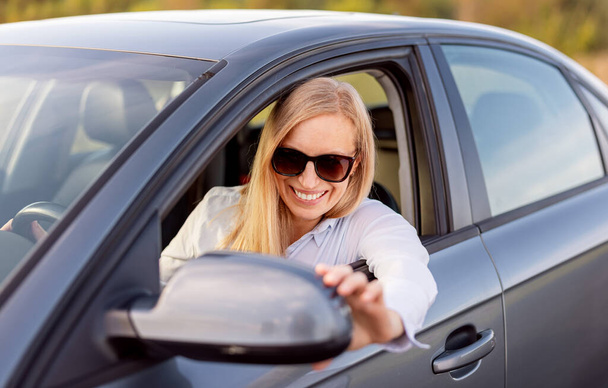 Female driver adjust side mirror - Foto, immagini