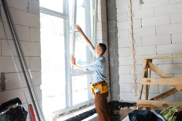 trabajador de la construcción instalando ventana en casa - Foto, imagen