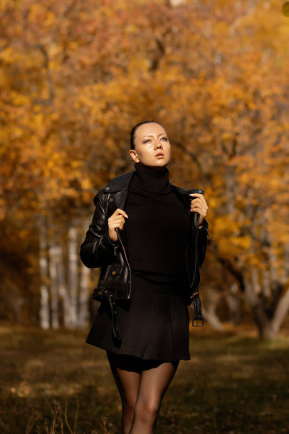 Сезонная осень. Современная молодая женщина в модной теплой одежде позирует в осеннем парке
. - Фото, изображение