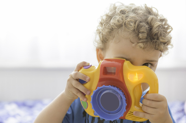 kind spelen met een speelgoed fotocamera - Foto, afbeelding
