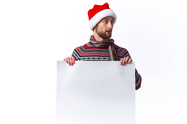 emotional man in a christmas hat with white mockup poster christmas isolated background - Photo, Image