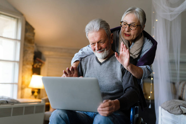 Happy senior couple using laptop at home and having fun together. Technology people concept - Fotoğraf, Görsel