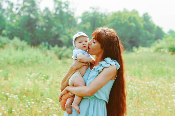 Mladá matka vychovala dítě v náručí - Fotografie, Obrázek