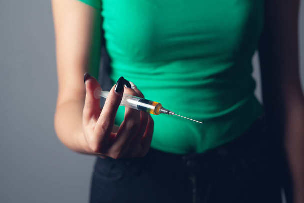 Девушка держит шприц с наркотиками - Фото, изображение