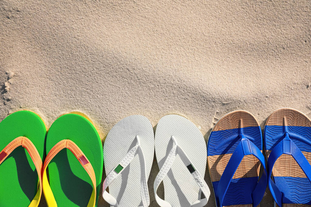 Stylish flip flops on beach, flat lay. Space for text - Foto, imagen